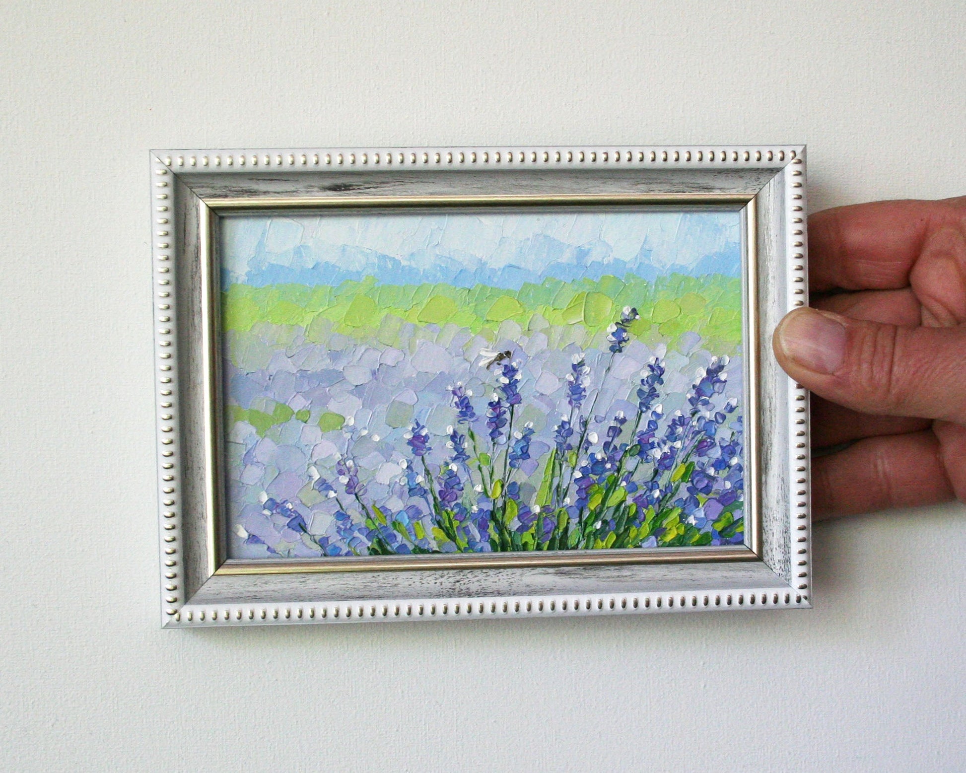 Framed mini oil painting of lavender flowers held by a hand 