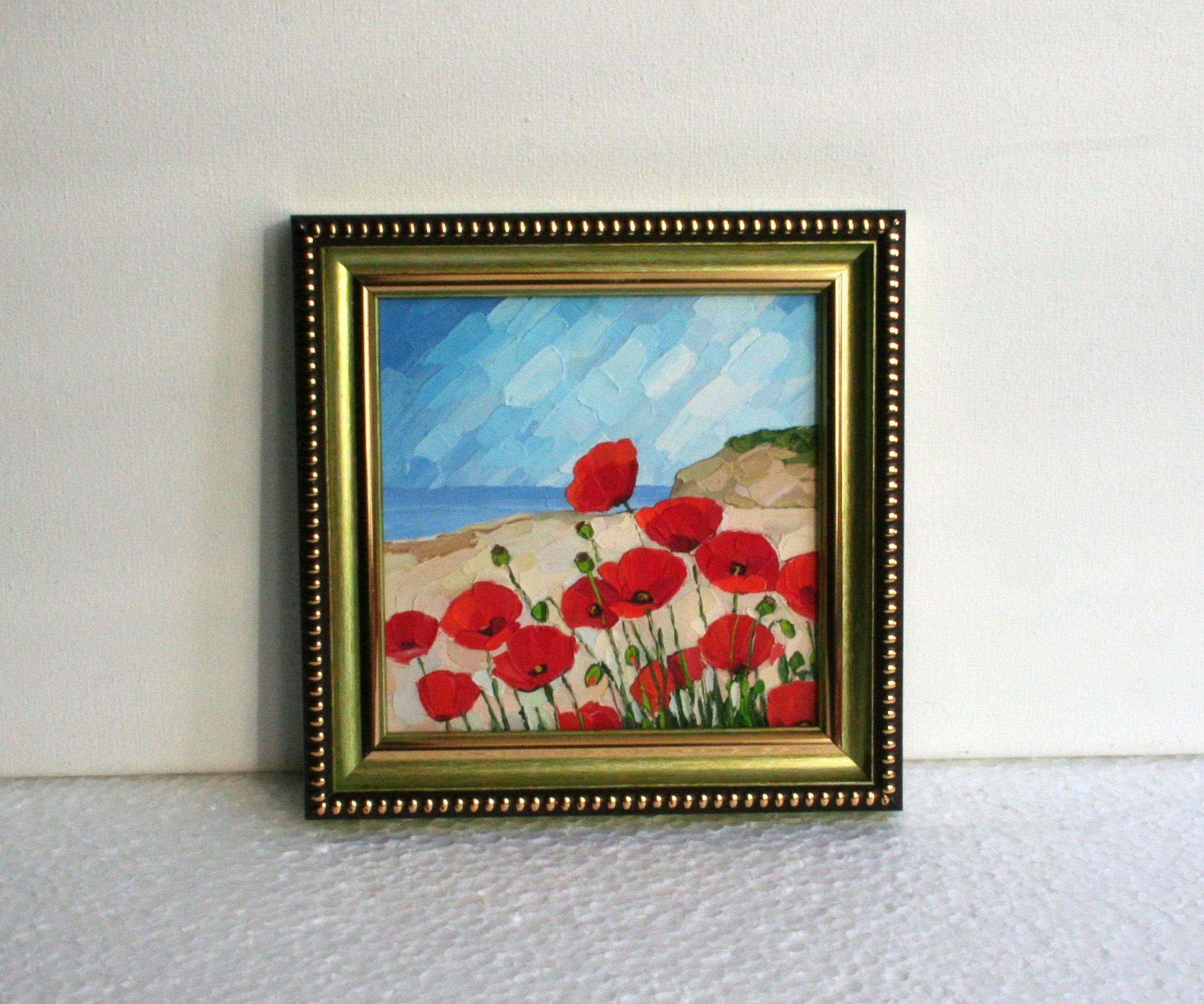 Framed small oil painting of red flowers with green frame