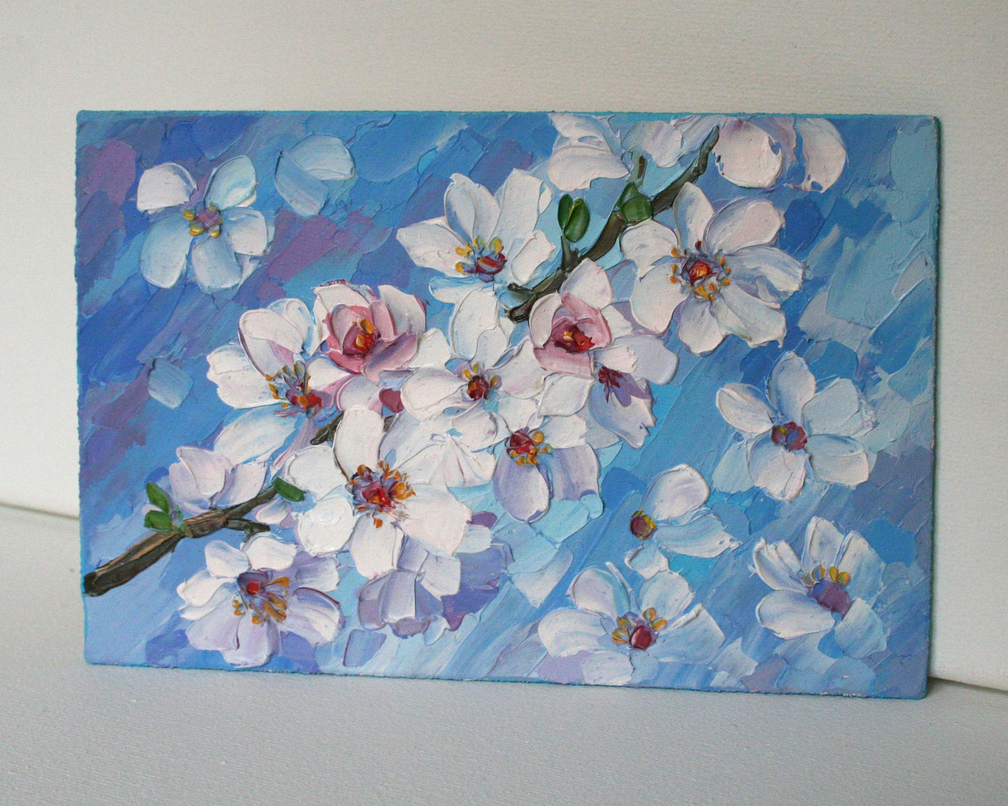 Mini oil painting of cherry blossoms on a blue background