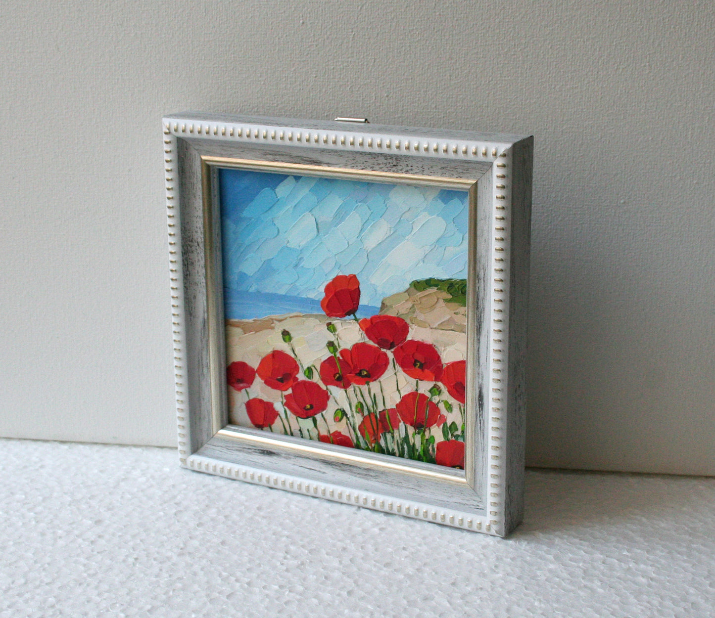 Original 4x4 red poppy mini oil painting, framed impasto palette knife art by Iryna Stakhiv. Ocean landscape background.