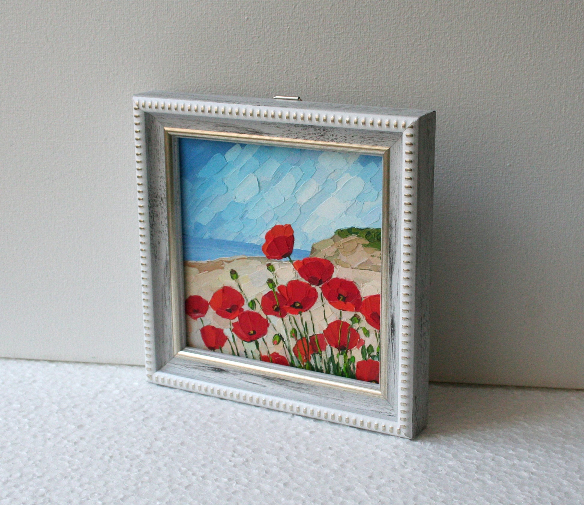 Original 4x4 red poppy mini oil painting, framed impasto palette knife art by Iryna Stakhiv. Ocean landscape background.