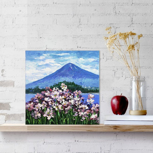 Painting of a mountain and flowers on a shelf 