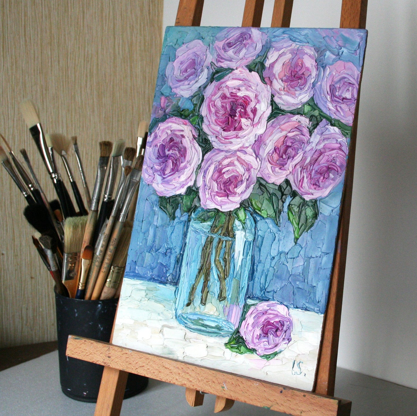 Textured oil painting of roses on an easel