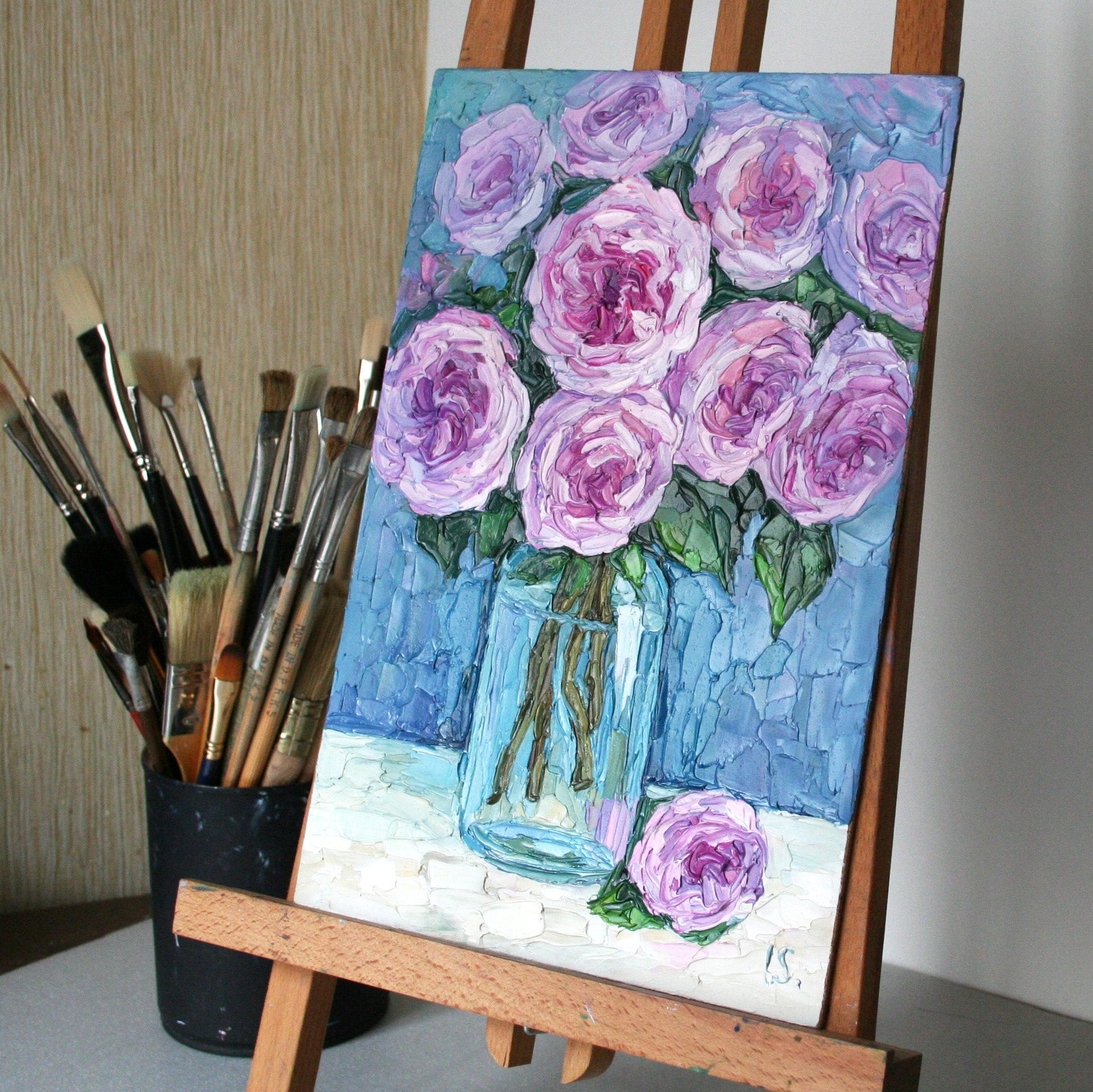 Textured oil painting of roses on an easel