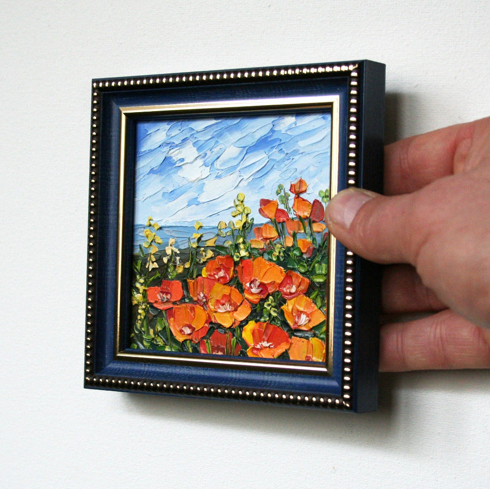 Textured palette knife strokes on a miniature poppy oil painting, thick impasto technique.